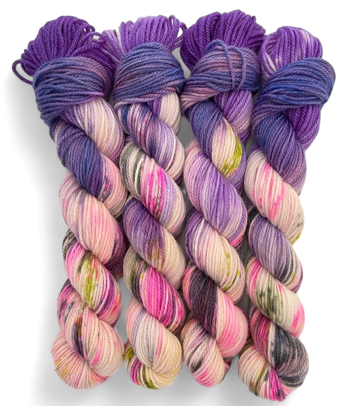 Four skeins of non superwash DK merino and bluefaced leicester yarn, hand dyed in shades of purple, violet and pink.