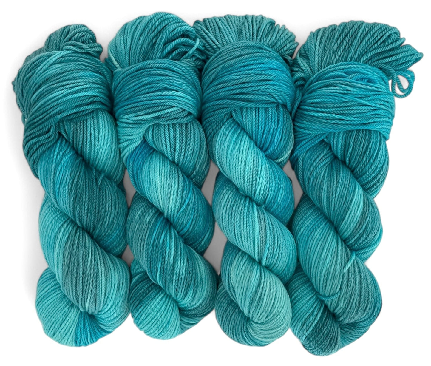 Four skeins of non superwash DK sustainable Merino woll, hand dyed in teal.