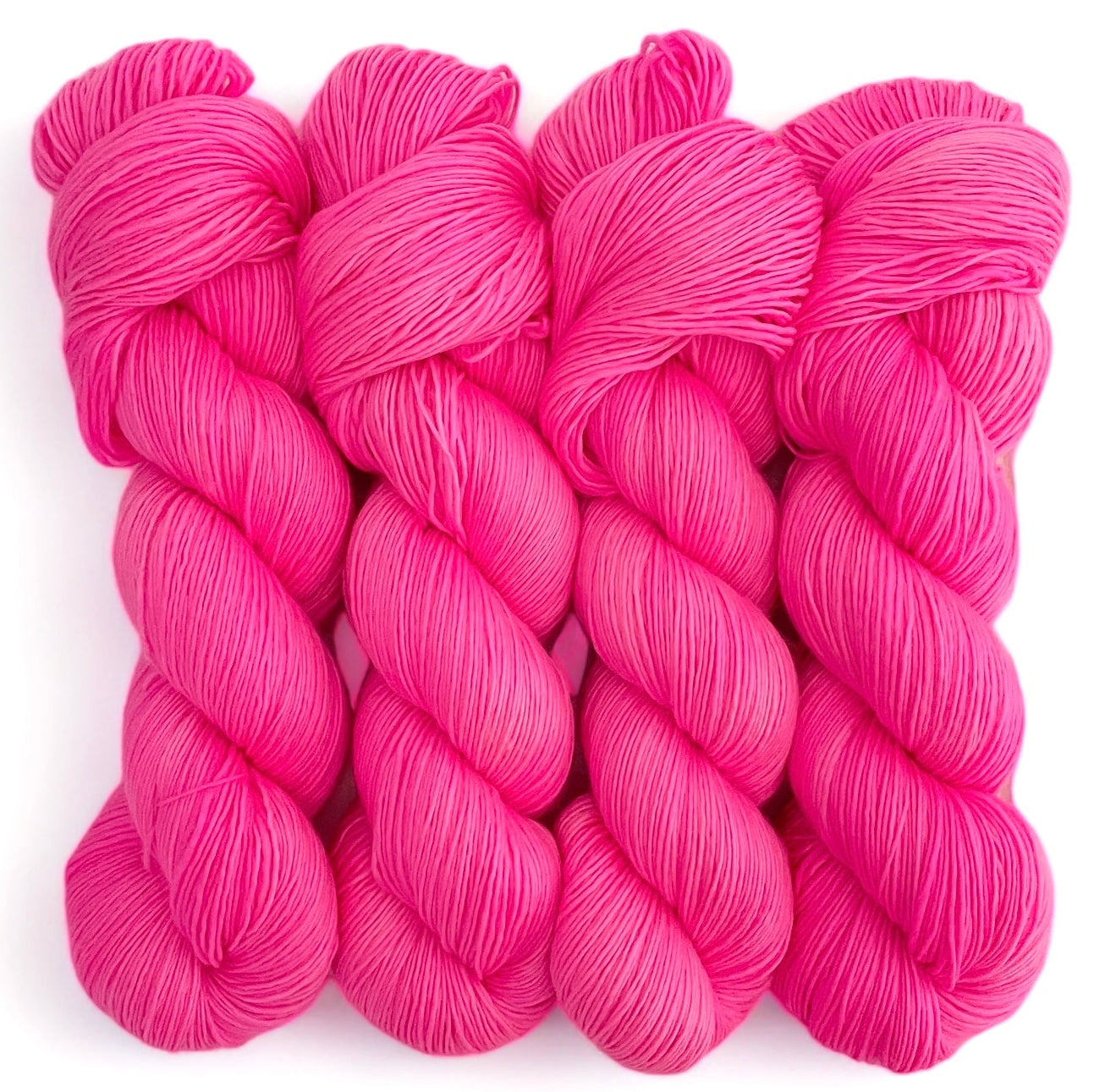 Four skeins of extrafine superwash sock weight merino wool, hand dyed in bright pink.
