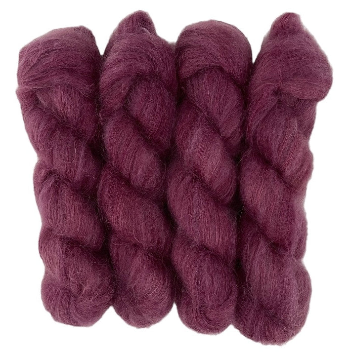 Four plum purple hand dyed skeins of lace weight mohair and silk yarn on a white background.