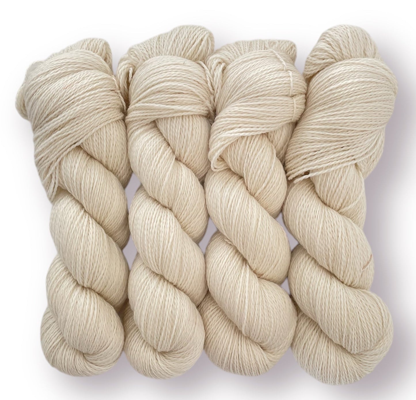 Four skeins of undyed beige Peruvian Highland fingering/sock weight non superwash wool yarn