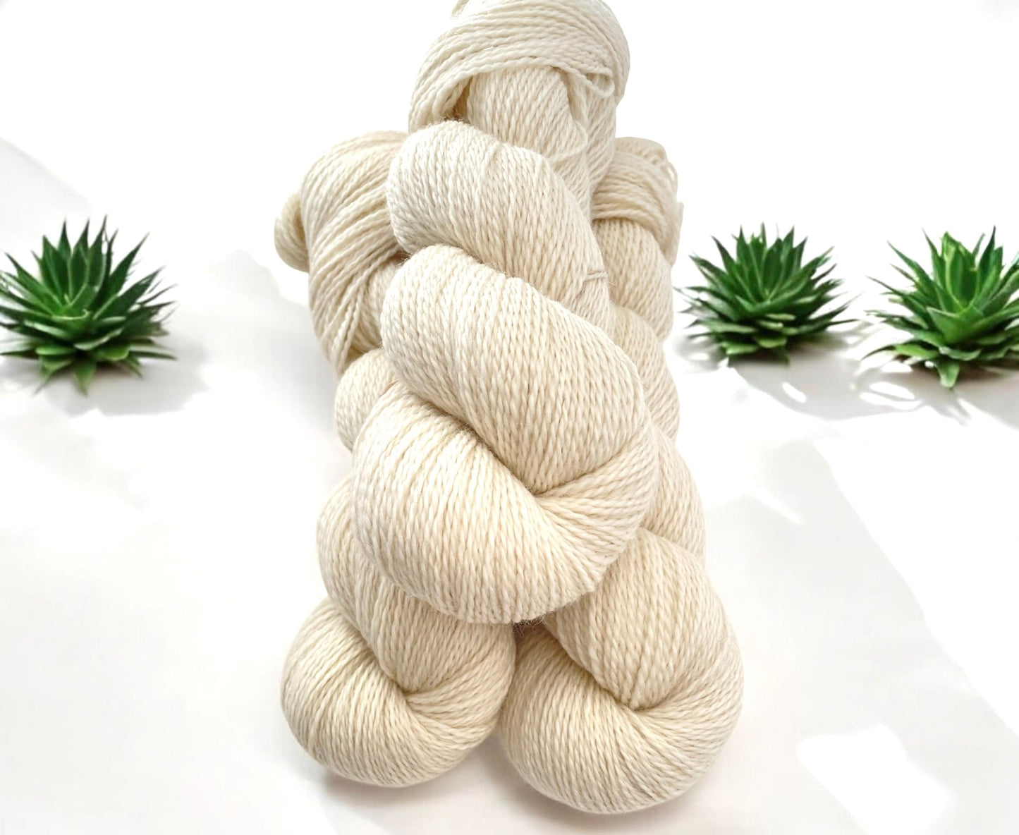Three skeins of undyed beige Peruvian Highland fingering/sock weight non superwash yarn