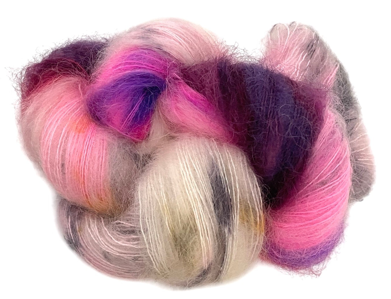 Close up of skein of lace weight mohair, hand dyed in shades of pink, purple and grey.