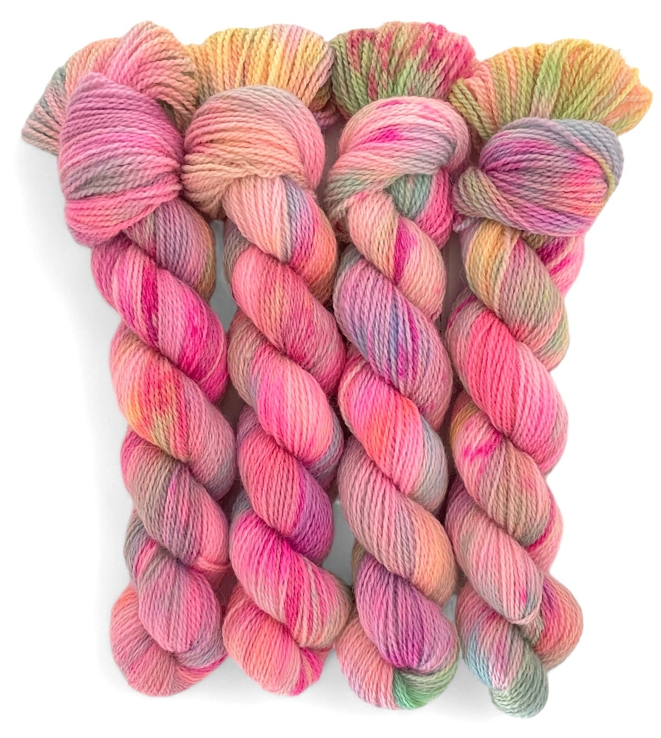 Four skeins of non superwash fingering weight merino and bluefaced leicester yarn, hand dyed in shades of pink, yellow and green.