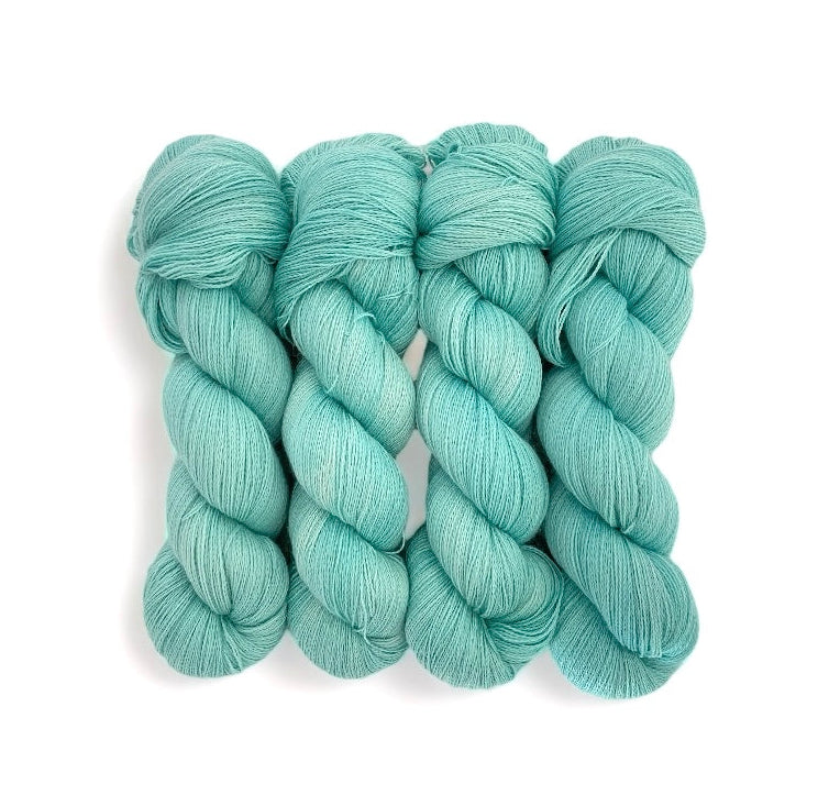 A skein of light blue, hand-dyed, semi-solid yarn made from 100% Baby Alpaca wool.
