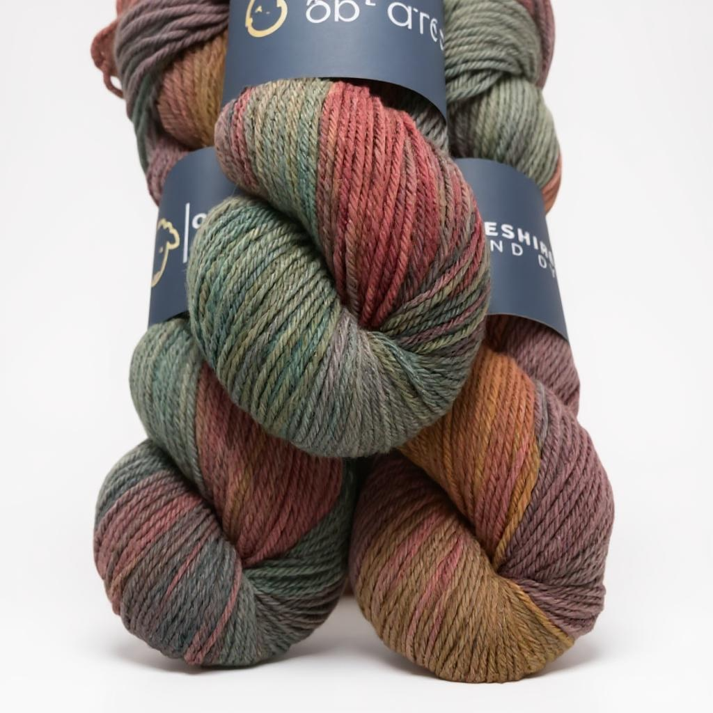 Three skeins of non superwash DK weight sustainable merino wool, hand dyed in shades of brown, grey and green.