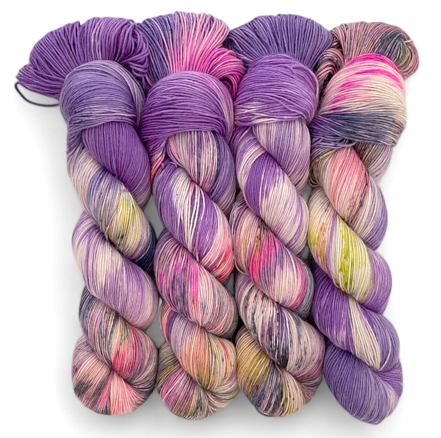 Four skeins of fingering weight baby alpaca, silk and cashmere yarn, hand dyed in shades of purple, pink and yellow.