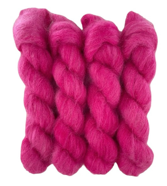 Four bright pink hand dyed skeins of lace weight mohair and silk yarn on a white background.