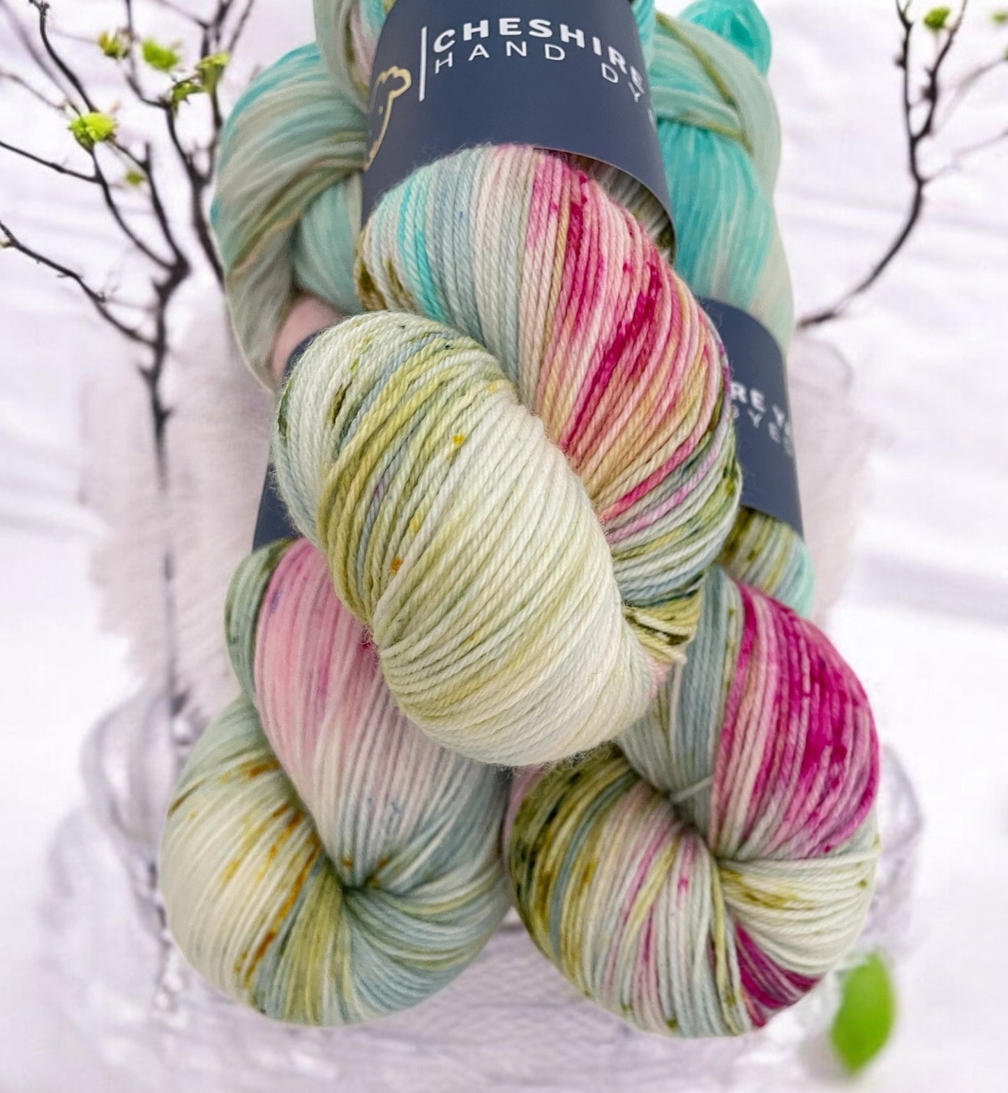 Three skeins of fingering sock weight superwash merino and nylon wool, hand dyed in pale shades of pink, yellow and green.