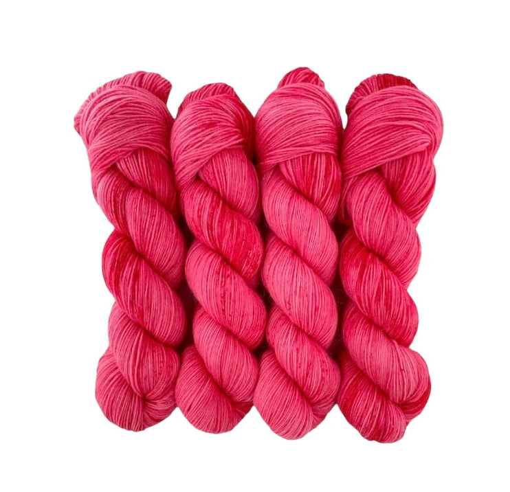 A skein of bright pink hand-dyed yarn.
