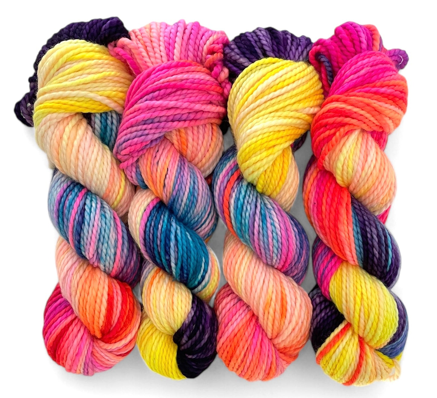 Four skeins of chunky weight superwash merino, hand dyed in bright colours including yellow, pink, blue and purple.