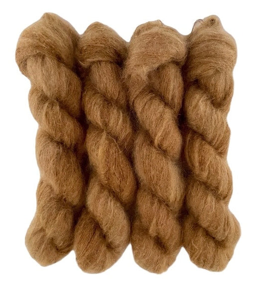 Four brown hand dyed skeins of lace weight mohair and silk yarn on a white background.