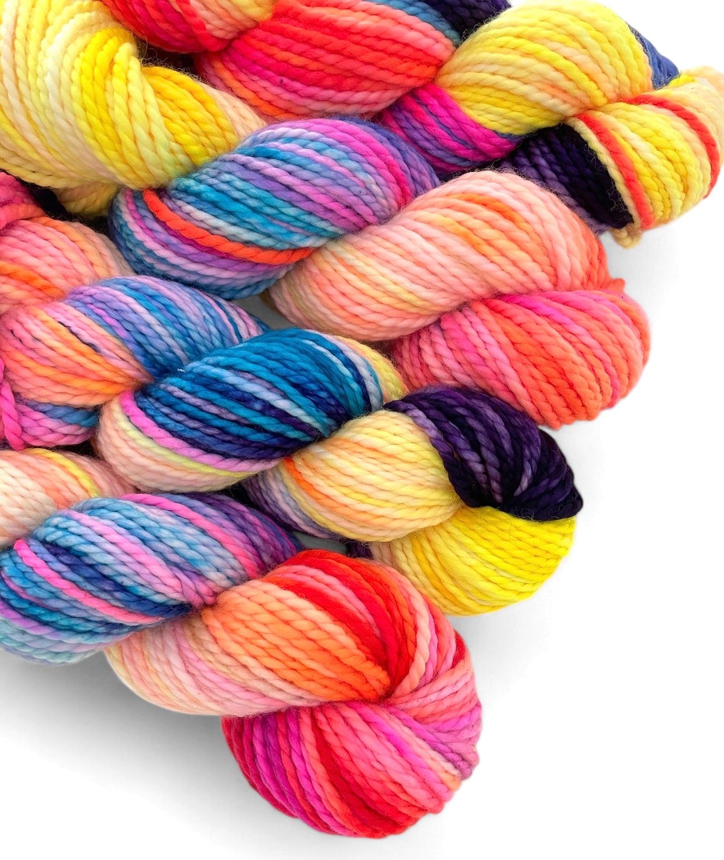 Four skeins of chunky weight superwash merino, hand dyed in bright colours including yellow, pink, blue and purple.