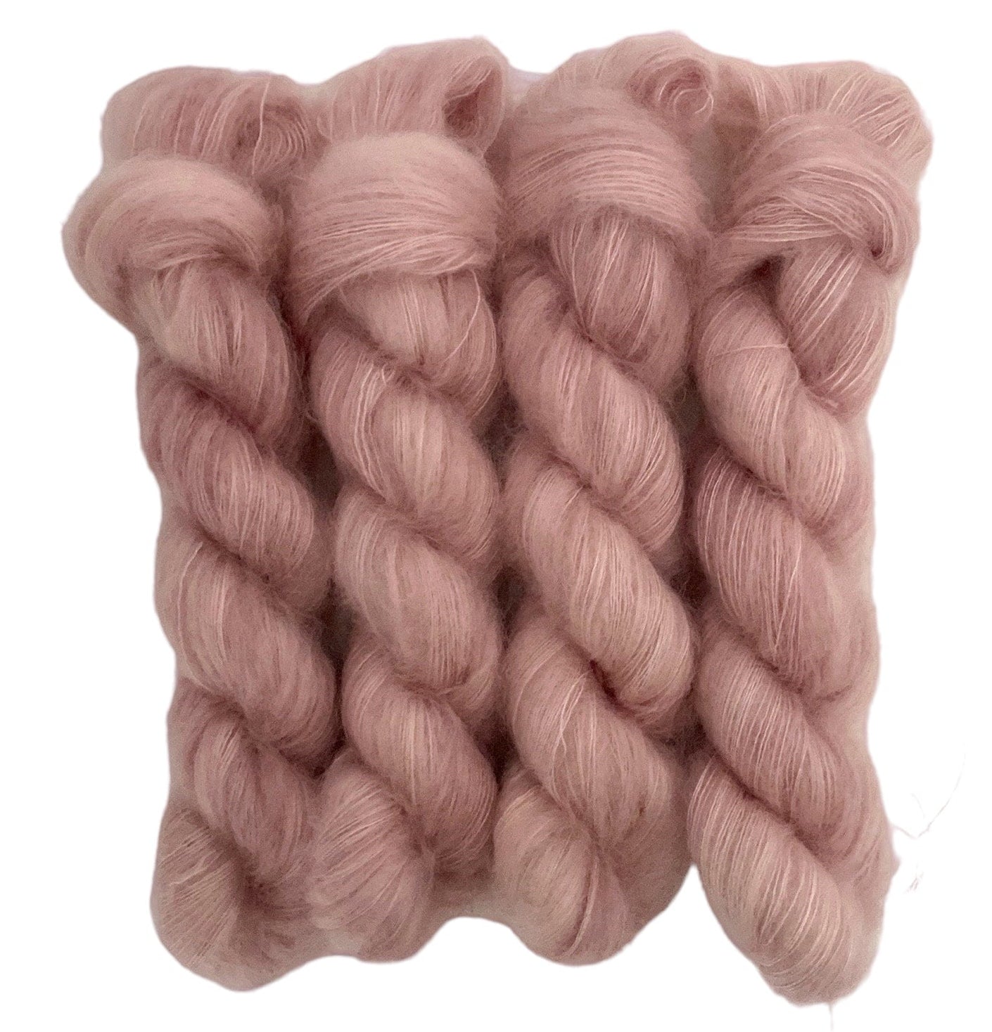 Four beige hand dyed skeins of lace weight mohair and silk yarn on a white background.