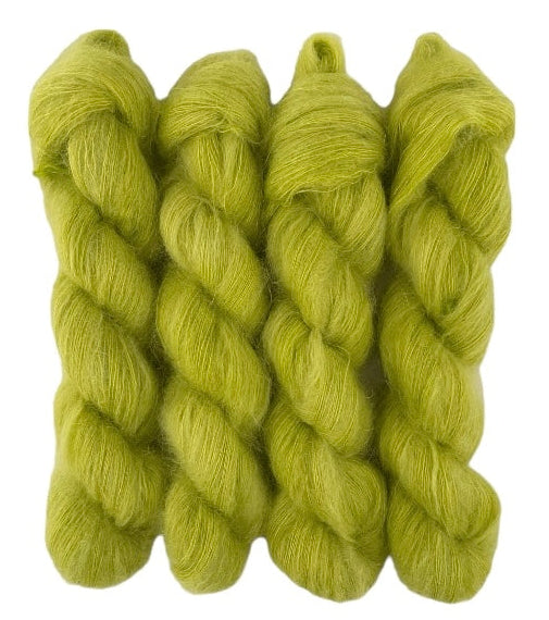 Four lime green hand dyed skeins of lace weight mohair and silk yarn on a white background.