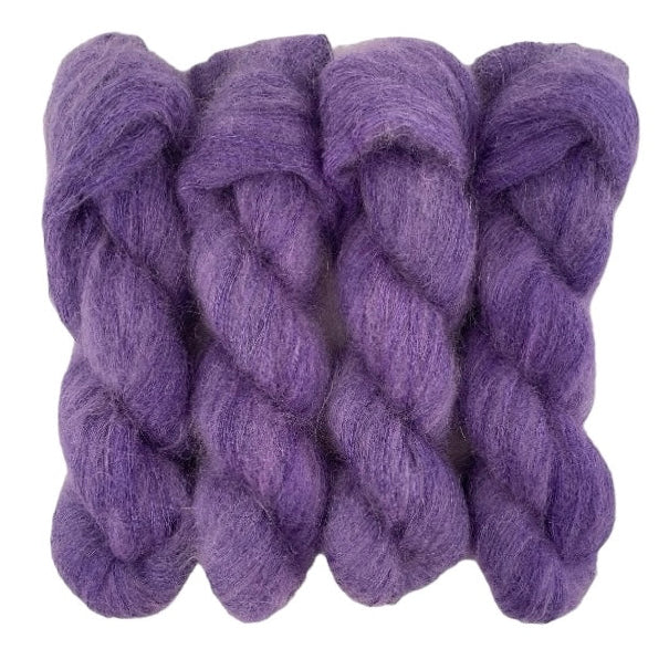 Four purple hand dyed skeins of lace weight mohair and silk yarn on a white background.