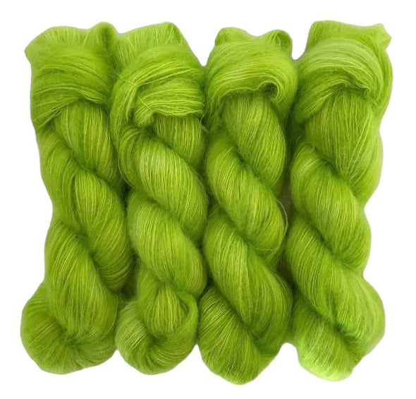 Four bright green hand dyed skeins of lace weight mohair and silk yarn on a white background.