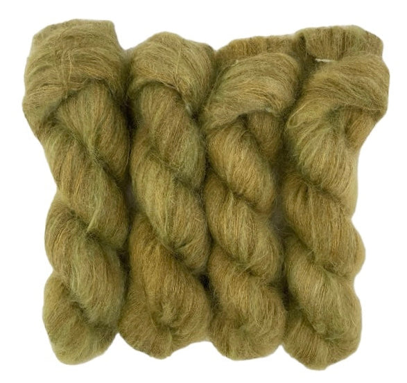 Four mustard brown hand dyed skeins of lace weight mohair and silk yarn on a white background.