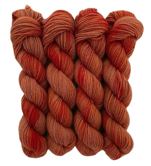 Four red and brown skeins of DK weight non superwash hand dyed merino and blue faced leicester.