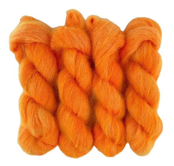 Four orange hand dyed skeins of lace weight mohair and silk yarn on a white background.