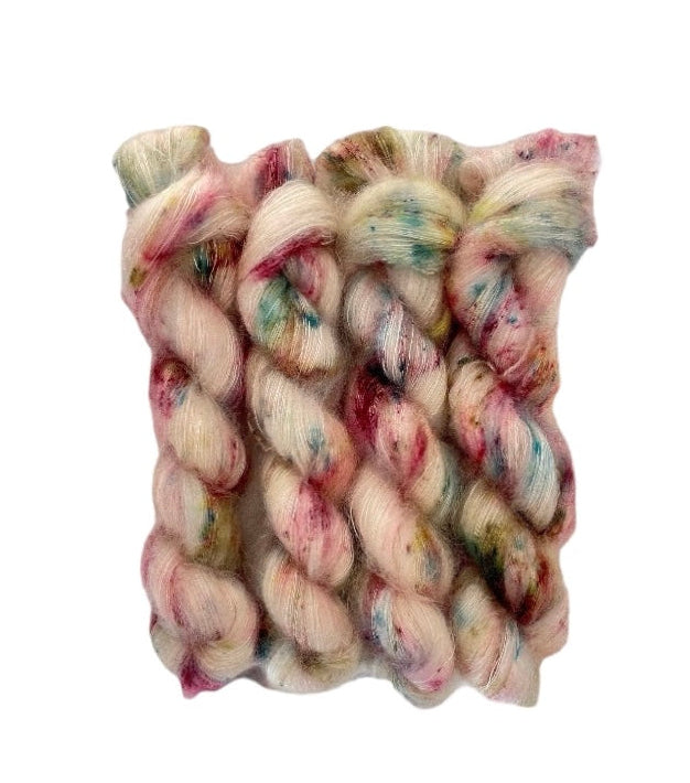 Expertly hand-dyed with a cream base and delicate dashes of green, blue, and berry colors, our COTTAGE GARDEN yarn is crafted from Kid Mohair and Silk for a luxurious lace weight feel. Enhance your projects with a touch of natural elegance.