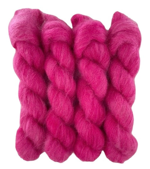 Four bright pink hand dyed skeins of lace weight mohair and silk yarn on a white background.
