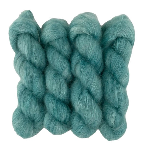 Four blue green hand dyed skeins of lace weight mohair and silk yarn on a white background.