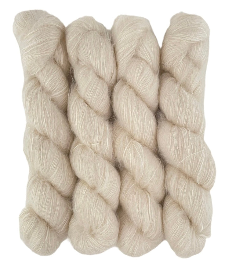 Four skeins of lace weight mohair and silk yarn on a white background.