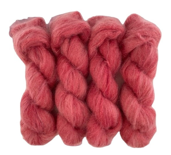 Four pale red rose hand dyed skeins of lace weight mohair and silk yarn on a white background.