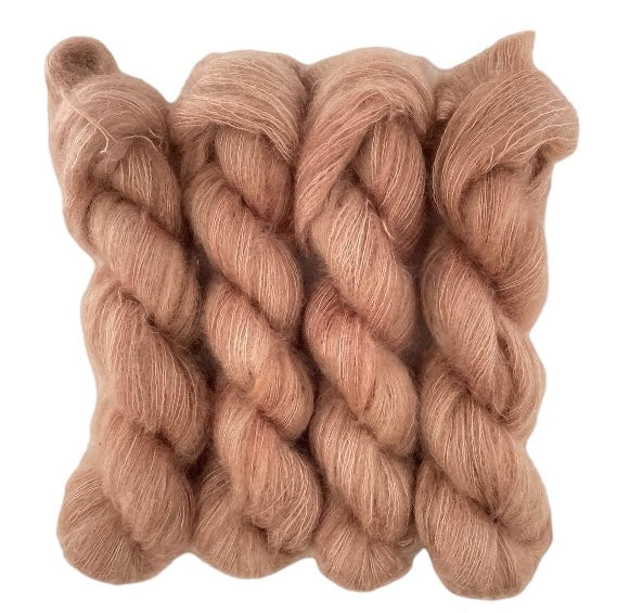 Four brown hand dyed skeins of lace weight mohair and silk yarn on a white background.