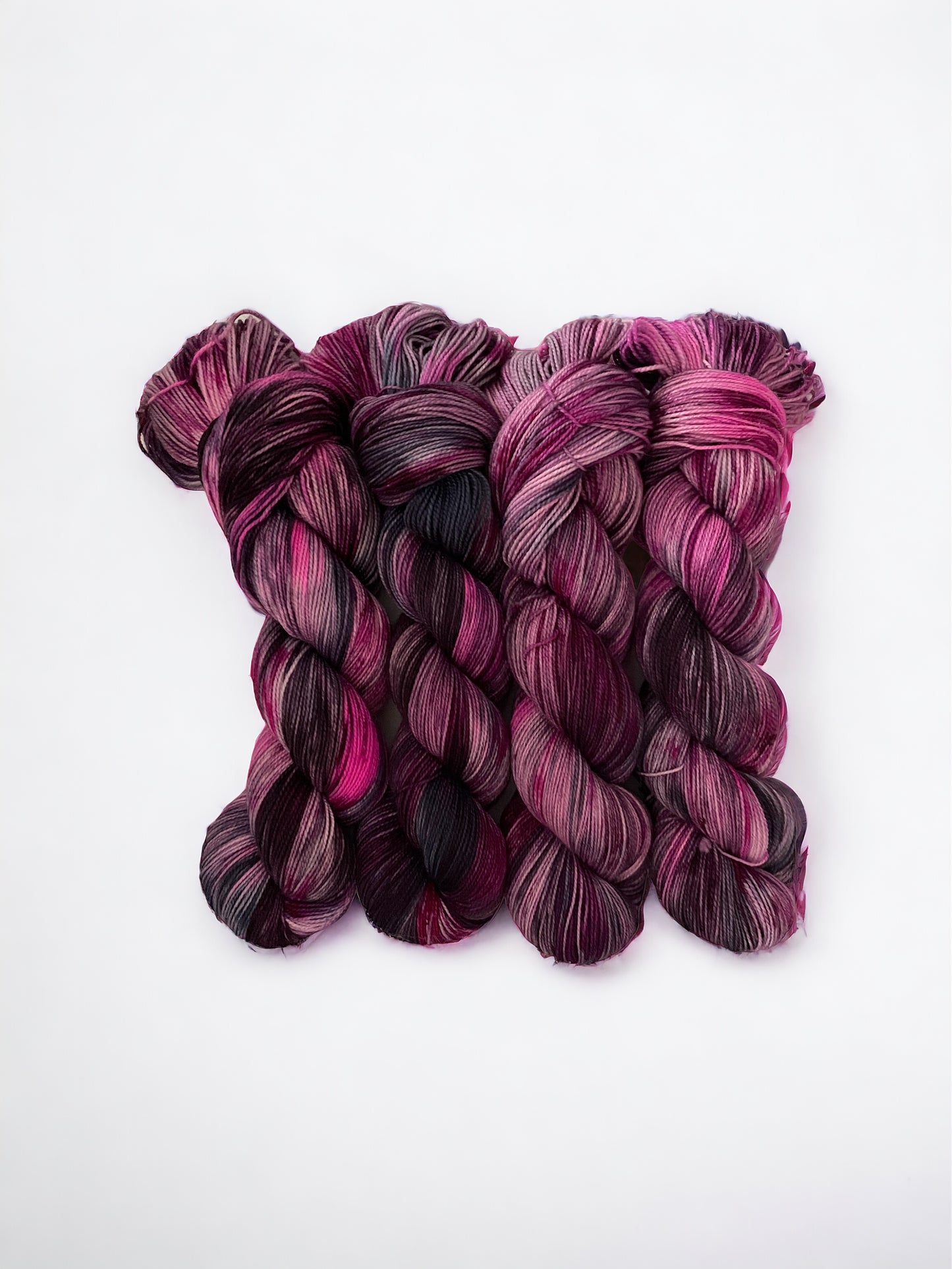 Hand Dyed 80% Superwash Blue Faced Leicester (BFL). 20% Nylon High Twist fingering weight.Indulge in the deep and rich hues of NIGHT PINK. Each skein of this hand dyed yarn boasts a mesmerizing dark pink & blue color that will elevate your knitting projects to new levels of sophistication. Made with care and expertise, this yarn is perfect for creating unique and eye-catching garments.