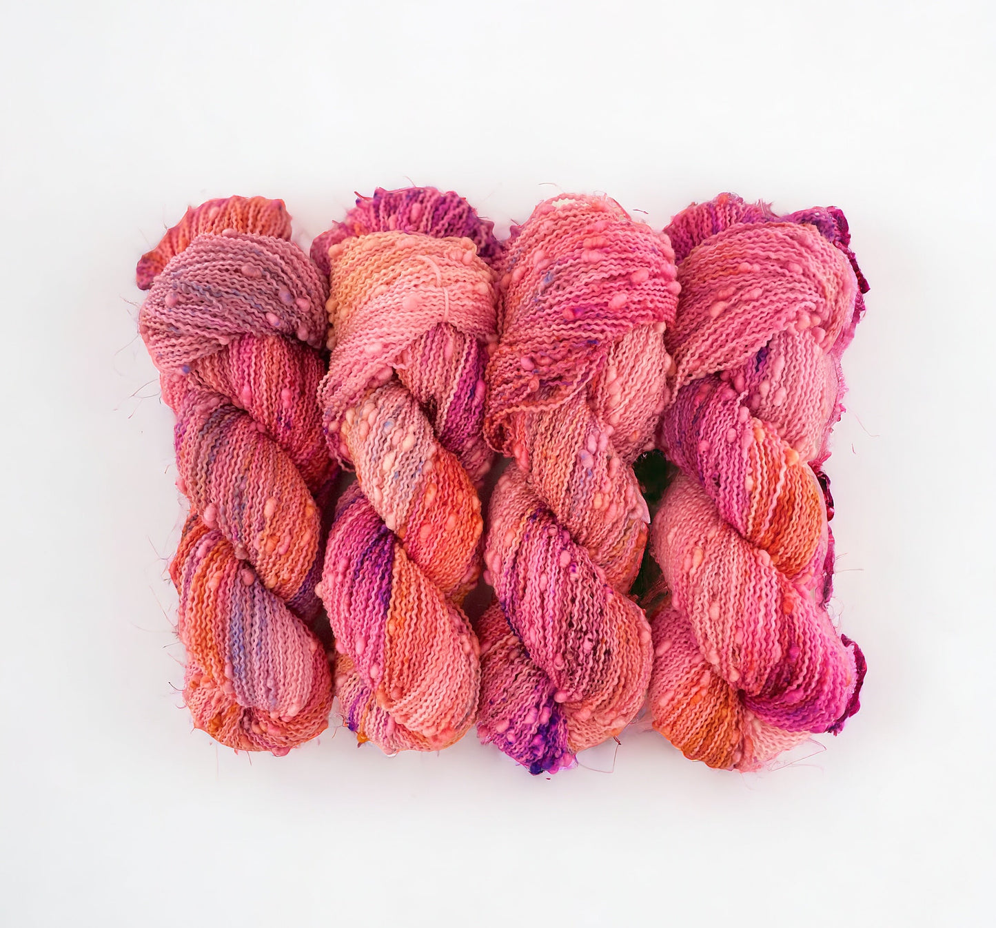 Bobble fingering/sock weight. 90% Super Wash Merino. 10% Nylon.Hand dyed in shades of coral and pink, this yarn brings a touch of warmth and vibrancy to any project. Perfect for sweaters and next to skin accessories.