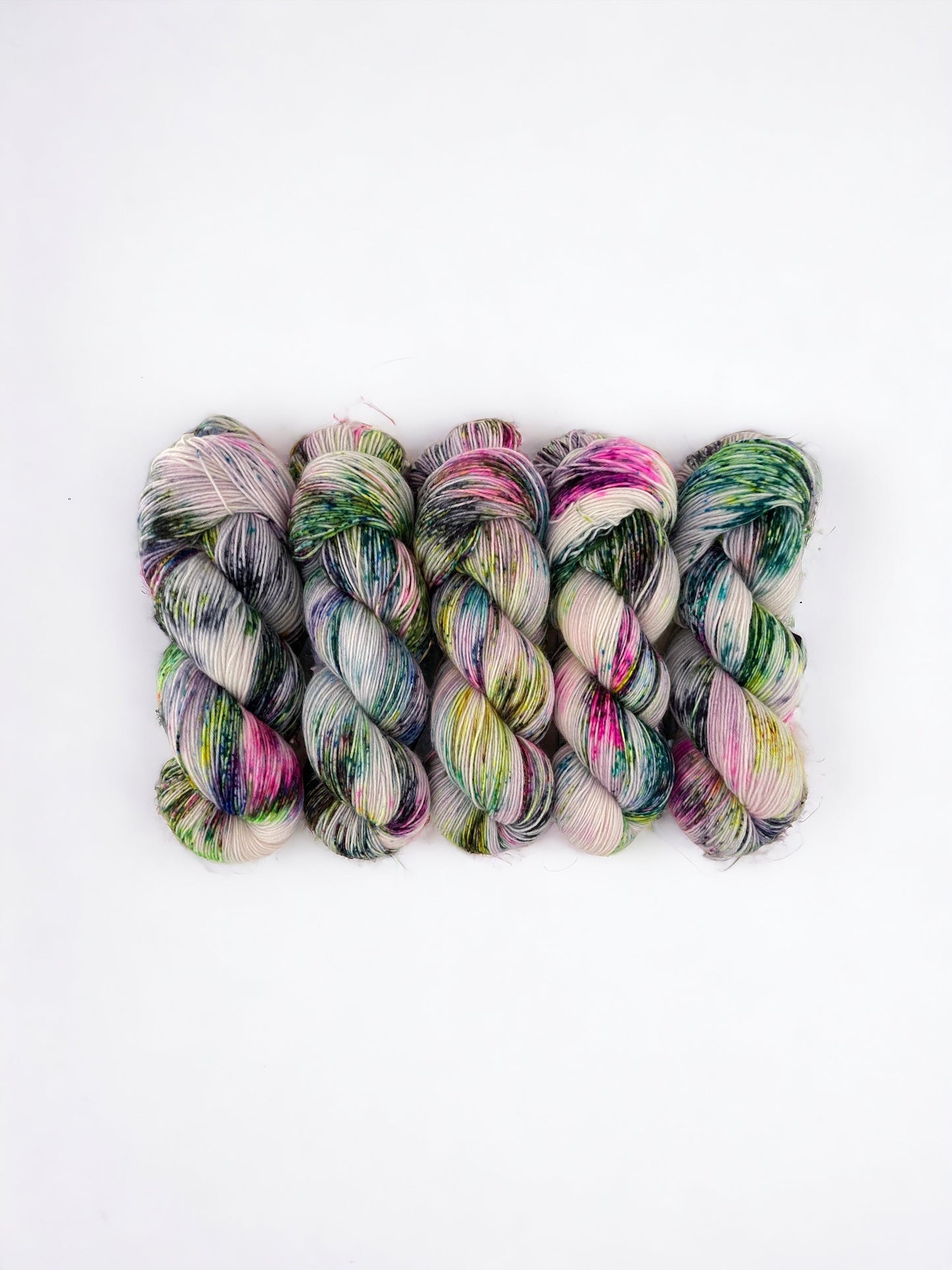 Hand dyed merino & nylon. A beautiful coloured yarn speckled green, pink, yellow & black on a white base.yarn