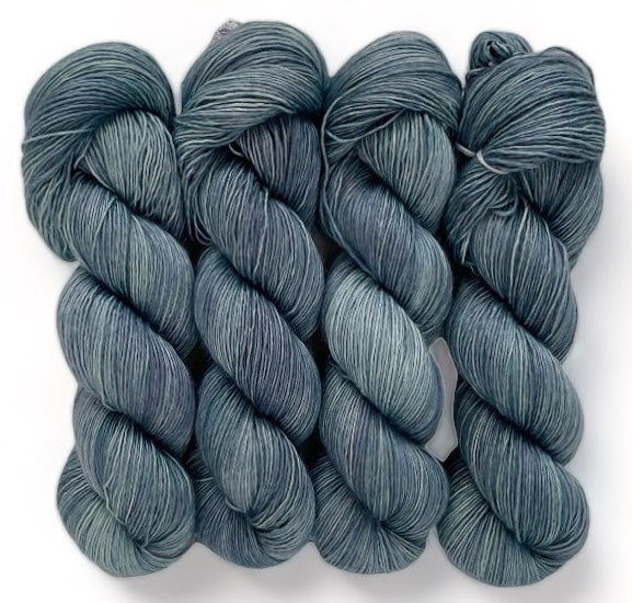 Four skeins of extrafine superwash sock weight merino wool, hand dyed in shades of blue
