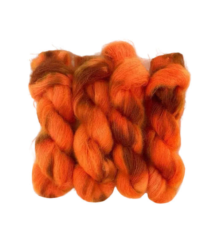This lace weight yarn blends superkid mohair and silk in a vibrant, bright orange hue with hints of brown. Each 50g skein is hand-dyed for a unique and luxurious touch to your knitting projects.