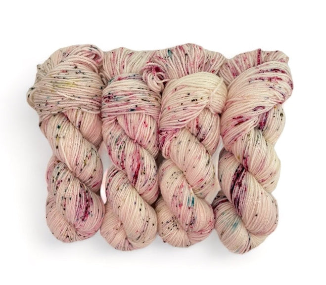 A skein of hand-dyed, multicolored yarn with a blend of merino wool and nylon fibers.