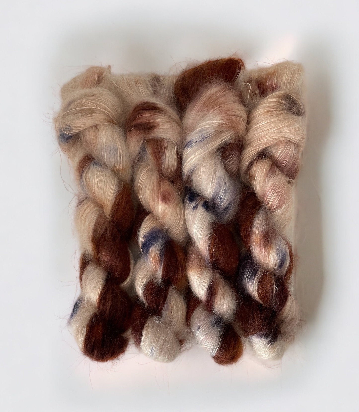 PUPPY LOVE hand-dyed yarn is a blend of kid mohair and silk, creating a soft and lightweight texture. The beautiful colors of cream, beige, brown & blue will add a unique touch to your knitting projects. Each 50g skein is carefully crafted for a truly one-of-a-kind piece.