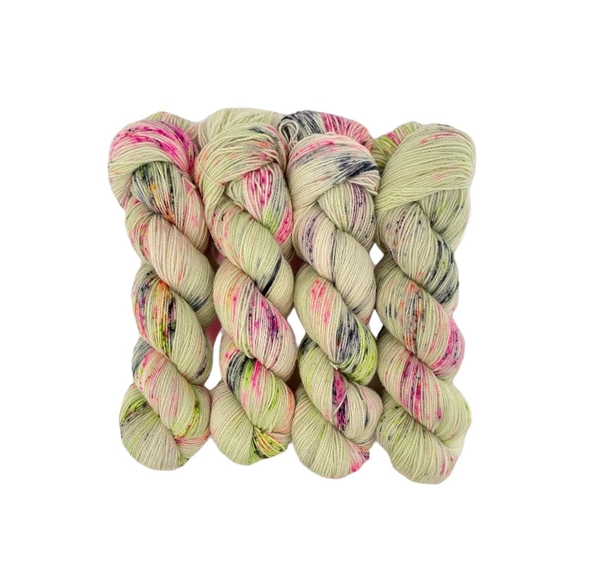 Experience the ultimate in softness and durability with our COOL SUMMER Hand Dyed Yarn. Made from a blend of Merino Wool and Nylon, this Fingering/Sock Weight Yarn is perfect for all your knitting & crochet projects. The pale green base is elevated with splashes of pink, orange, and black, adding a unique touch to your designs.