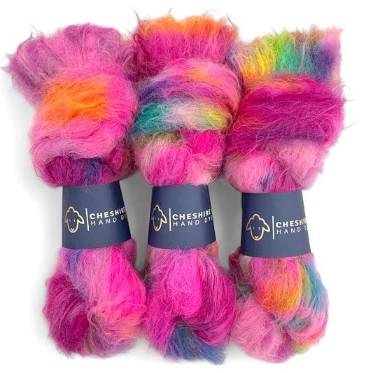 Three skeins of multicolored baby alpaca and merino yarn with 'Cheshire Yarn Hand Dyed' labels on a white background