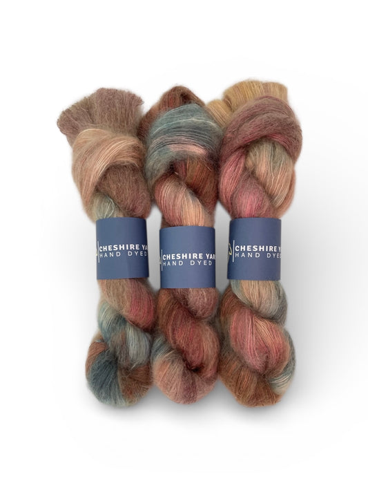 Three skeins of multi-coloured hand-dyed Cheshire Yarn, Lace weight Mohair and Silk blend on a white background