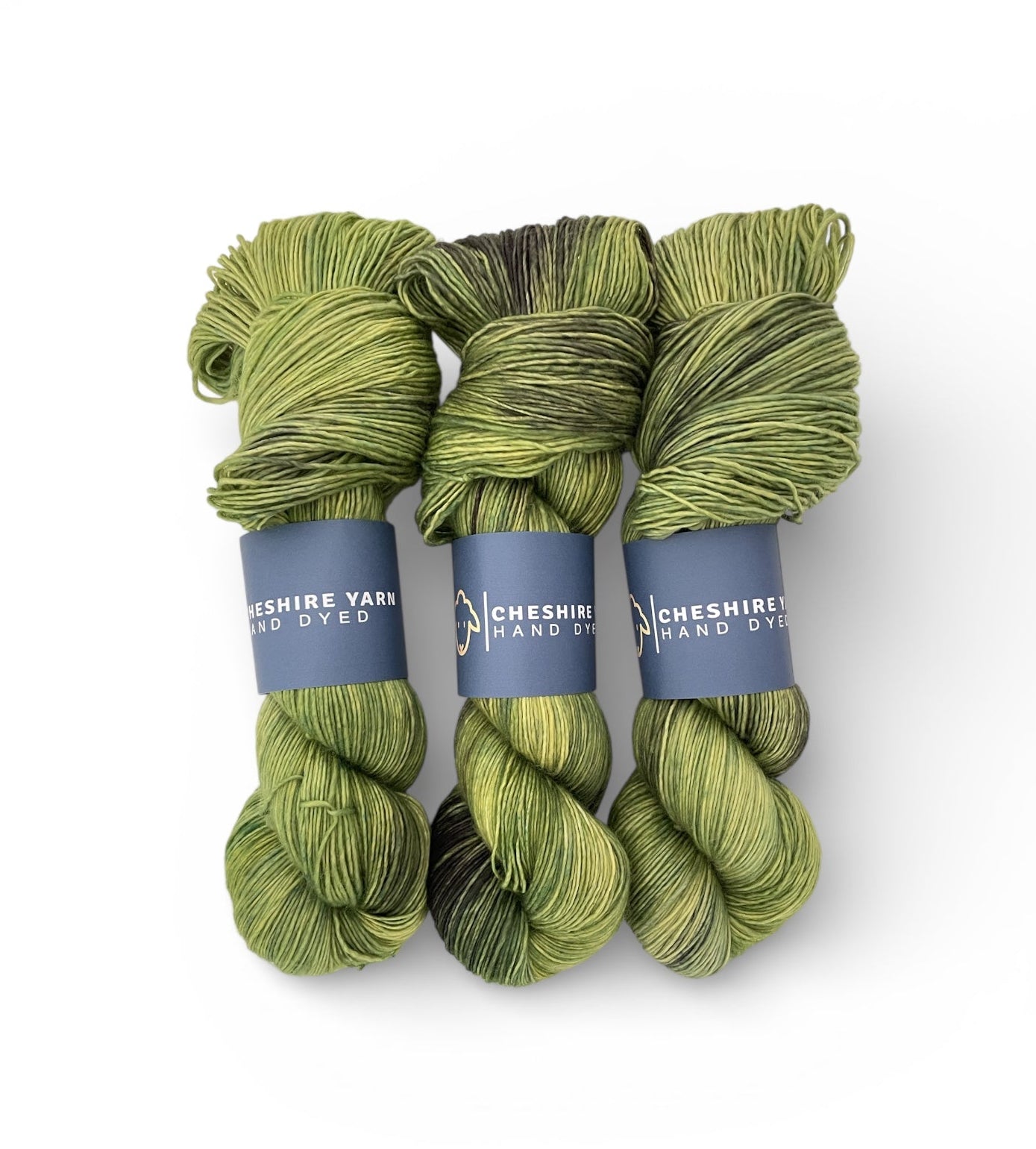 Three skeins of green yarn with blue labels on a white background