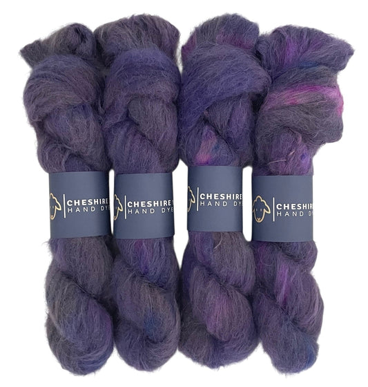 Four skeins of lace weight suri alpaca yarn, hand dyed in shades of purple.