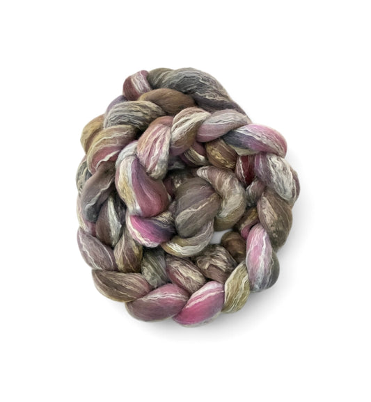 A coiled skein of variegated yarn with blended shades of dusty pink, mauve, gray, taupe, and olive green, isolated on a white background.