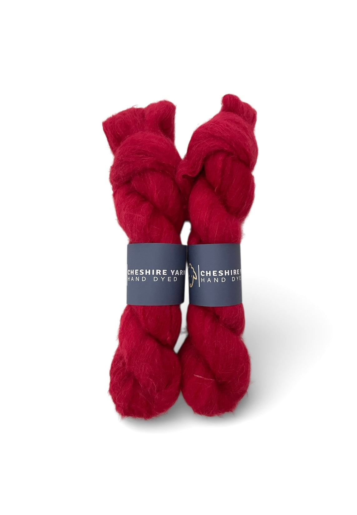 Two skeins of red  lace weight Suri Alpaca & Silk, Cheshire Yarn brand on white background.