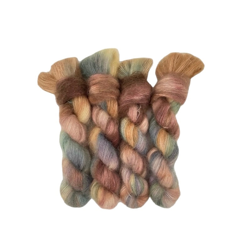 This luxurious DUSTY PATH hand-dyed yarn is a blend of kid mohair and silk, creating a soft and lightweight texture. The beautiful colors of beige, brown, sage, and lilac will add a unique touch to your knitting projects. Each 50g skein is carefully crafted for a truly one-of-a-kind piece.