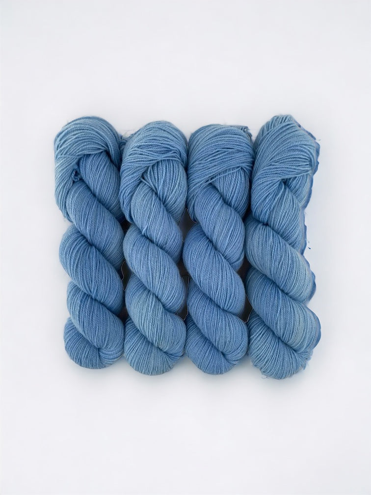 BLUE HAWAIIAN - Hand Dyed Yarn. This fingering/sock weight yarn is made with superwash Blue Faced Leicester wool and nylon, offering both durability and softness. Each 100g skein is hand dyed, giving it a unique and vibrant color. Perfect for any knitting or crocheting project.