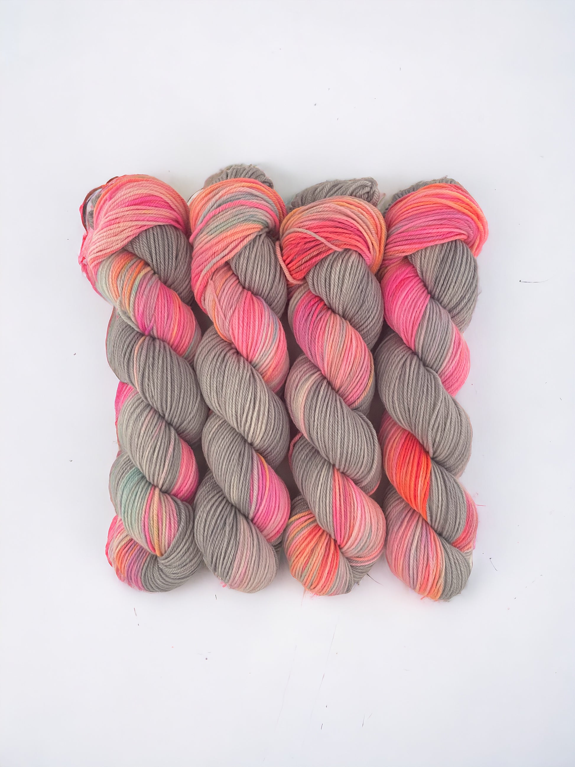 Hand dyed yarn.  100% Fine Organic Merino Wool .Introducing PIZZAZZ, the ultimate blend of style and sustainability. Made from 100% organic merino wool, our hand-dyed grey and pink fabric offers a luxurious and eco-friendly choice for your wardrobe. 