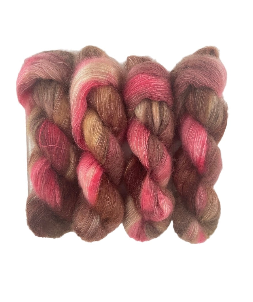 Introducing STRAWBERRY FUDGE a luxurious hand-dyed yarn made with a blend of soft Superkid Mohair and Silk. Each 50g skein features beautiful shades of chocolate brown and pink, perfect for creating delicate and elegant lace projects. 