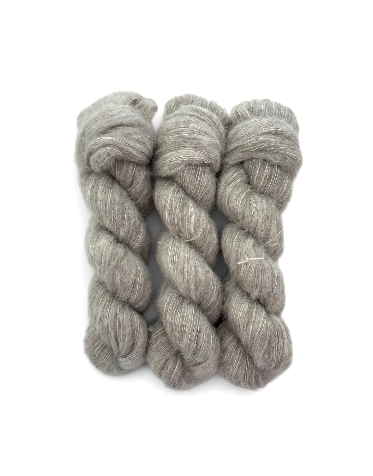 Three skeins of heathered light gray wool yarn arranged side by side on a plain white background.