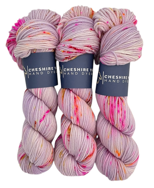 Three skeins of DK superwash merino and nylon yarn, hand dyed in shades of pink and lilac.